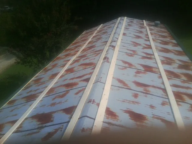 Rusted metal roof panels with new wood purlins before replacement — Storm Damage Roof Repair in Social Circle by Roofing Brothers