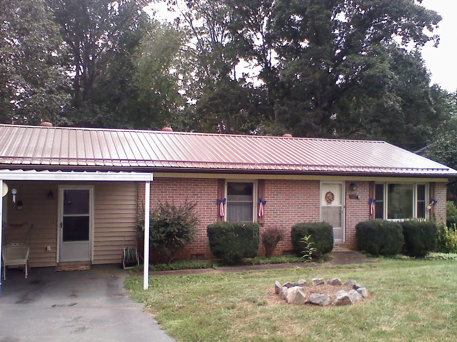 Bronze metal roof and carport on a brick ranch home — Roof Repair work by our crew in Social Circle