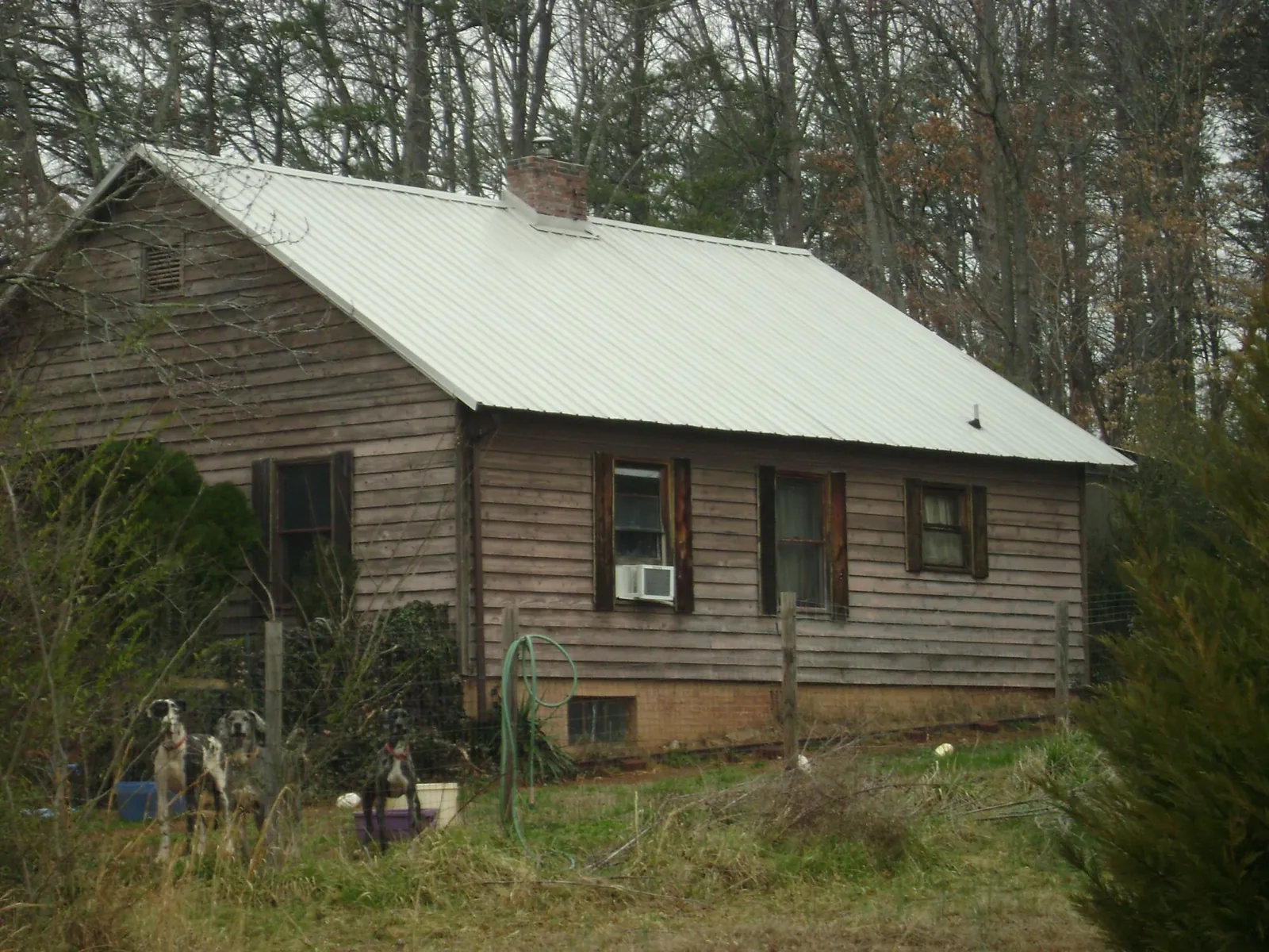 White metal roof on an old wood sided farmhouse, from a Metal Roof Installation job in Social Circle